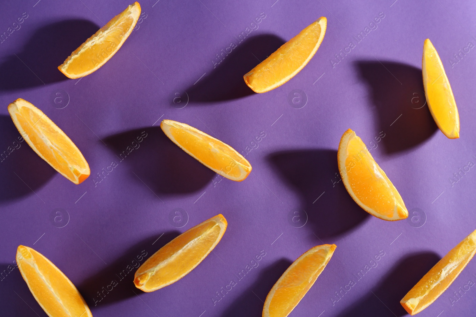 Photo of Slices of delicious oranges on purple background, flat lay