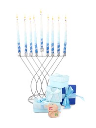 Photo of Hanukkah celebration. Menorah with candles, gift boxes and wooden dreidels isolated on white
