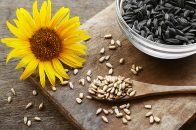 Sunflower seeds and flower on wooden table