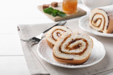 Photo of Tasty cake roll with jam on white wooden table. Space for text