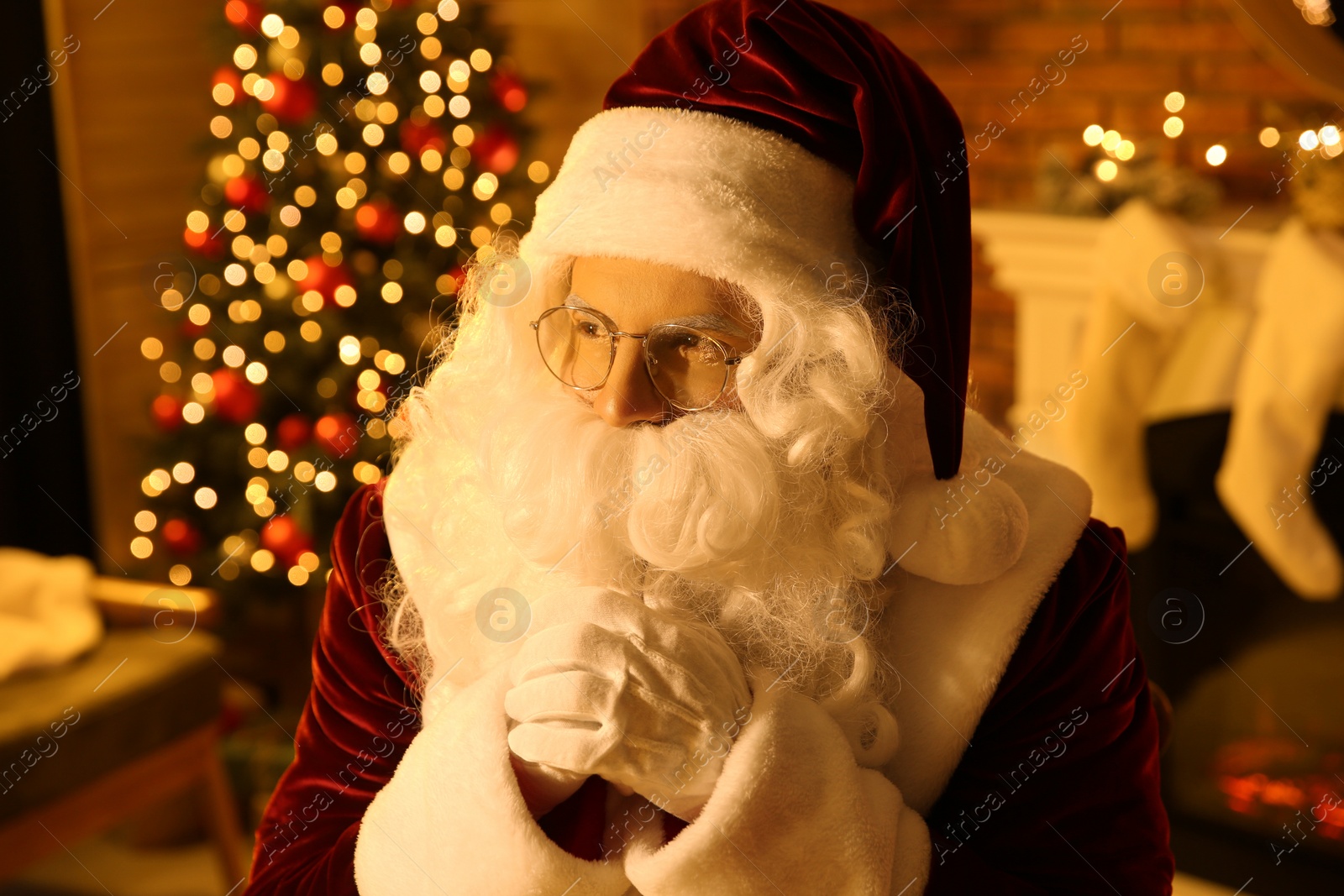 Photo of Santa Claus with glasses in festively decorated room
