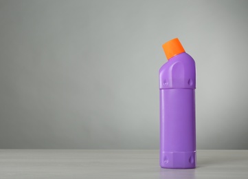 Photo of Bottle of cleaning product on light table. Space for text