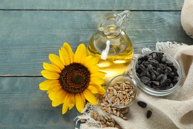 Sunflower, oil and seeds on light blue wooden table