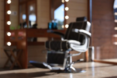 Photo of Blurred view of stylish barbershop interior with hairdresser workplace