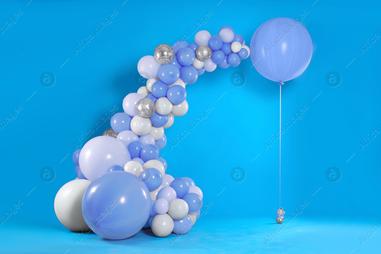 Image of Balloon garland near light blue wall. Festive decor