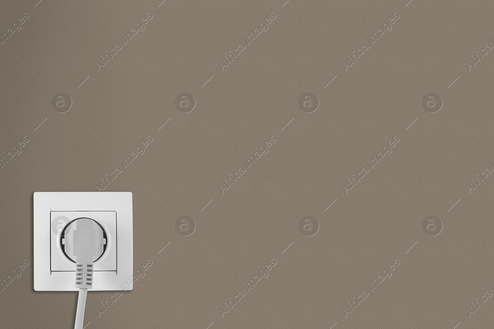 Brown wall with power socket and inserted plug, space for text. Electrical supply Image of Brown wall with power socket and inserted plug, space for text. Electrical supply