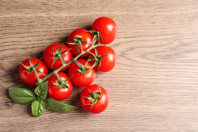 Photo of Fresh cherry tomatoes on wooden background, top view. Space for text