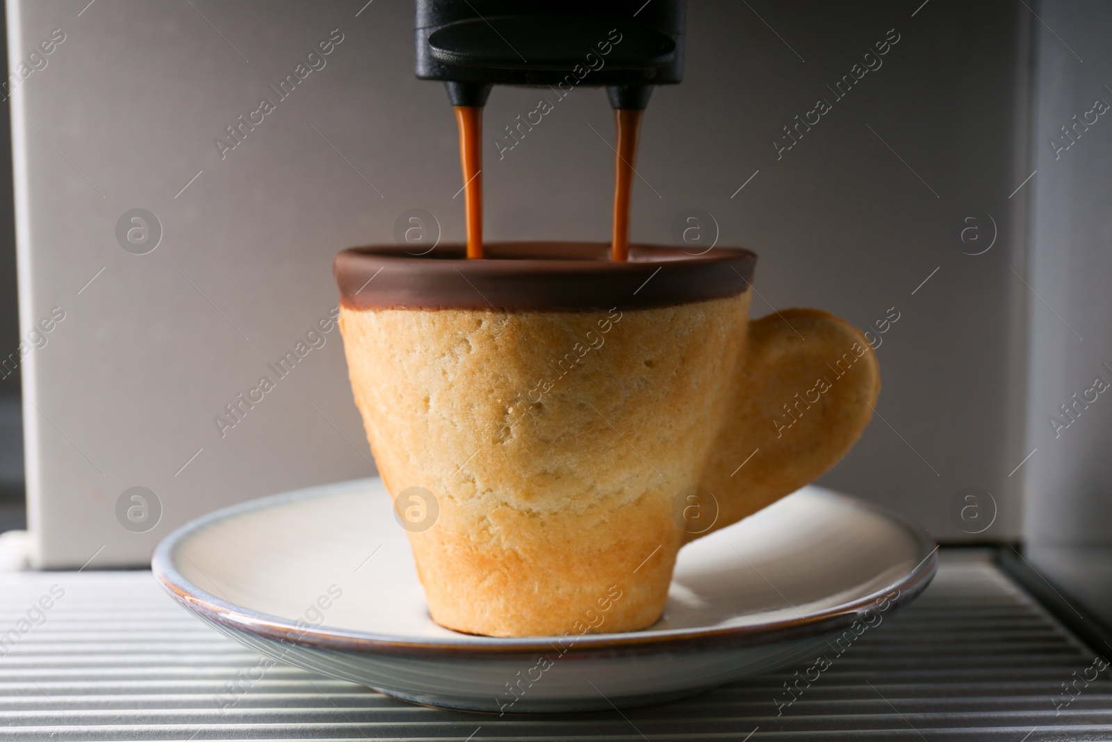 Photo of Coffee machine pouring espresso into edible biscuit cup