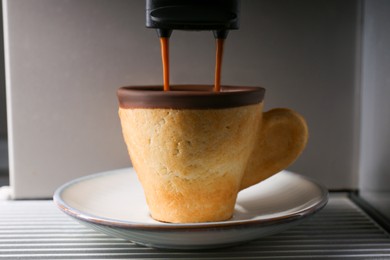Photo of Coffee machine pouring espresso into edible biscuit cup