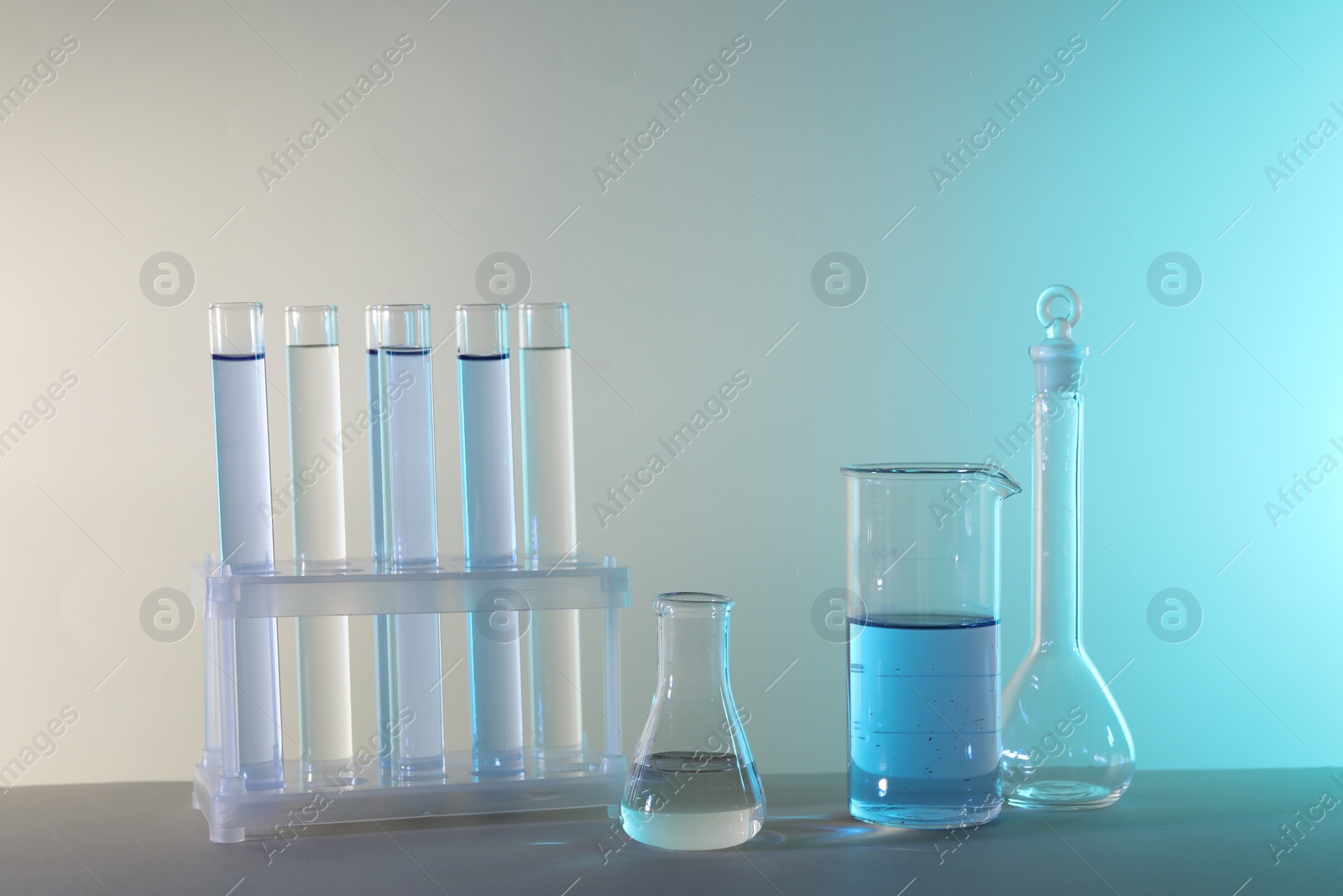 Photo of Laboratory analysis. Different glassware on table against color background