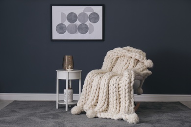 Rocking chair with white knitted plaid in room. Interior design