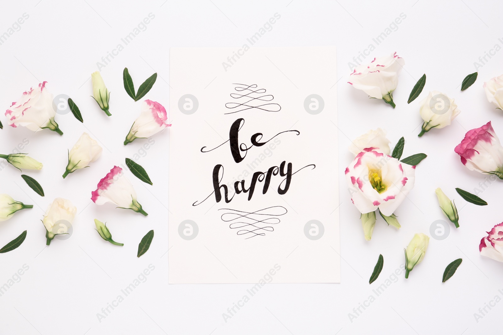 Photo of Frame of beautiful flowers and paper card with handwritten text Be happy on white background, flat lay