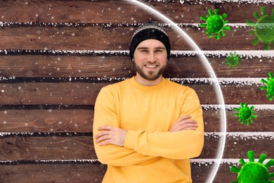 Man with strong immunity surrounded by viruses near wooden wall outdoors in winter