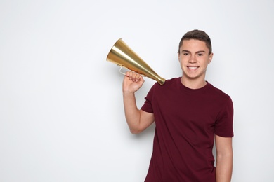 Teenage boy with megaphone on white background. Space for text