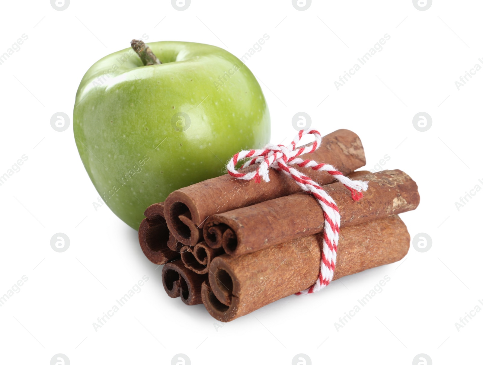 Photo of Cinnamon sticks and green apple on white background