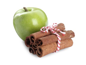 Cinnamon sticks and green apple on white background