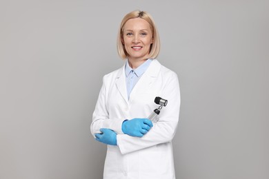 Happy dermatologist with dermatoscope on grey background