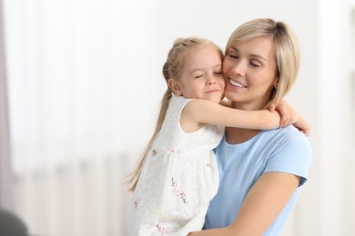 Photo of Daughter hugging her happy mother at home. Space for text