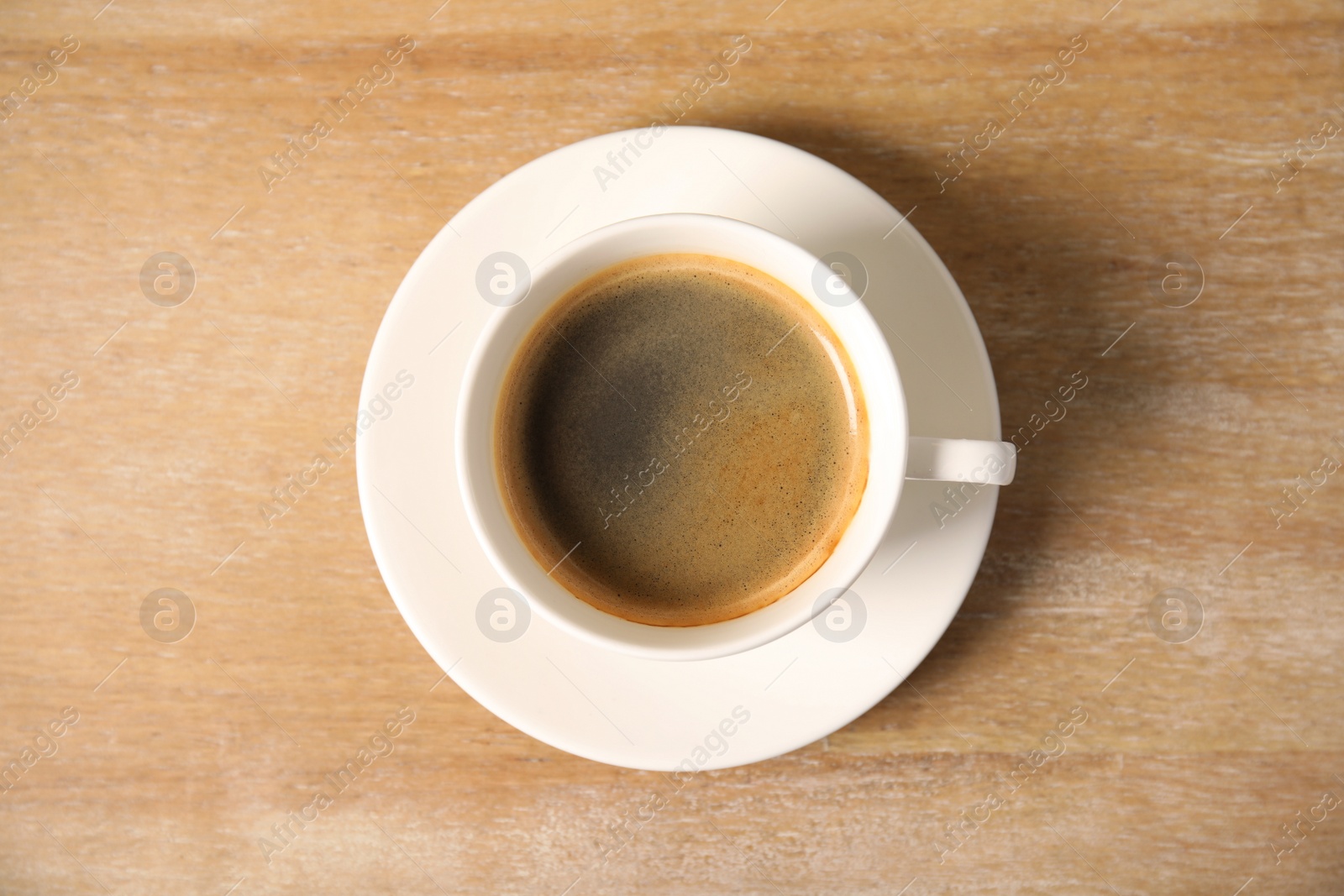 Photo of Cup of delicious hot coffee on wooden background, top view