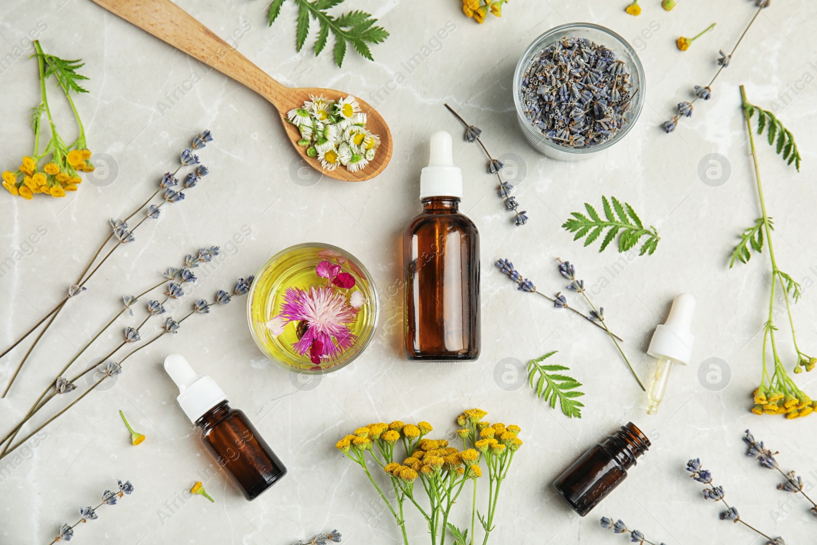 Photo of Flat lay composition with essential oils and flowers on light background