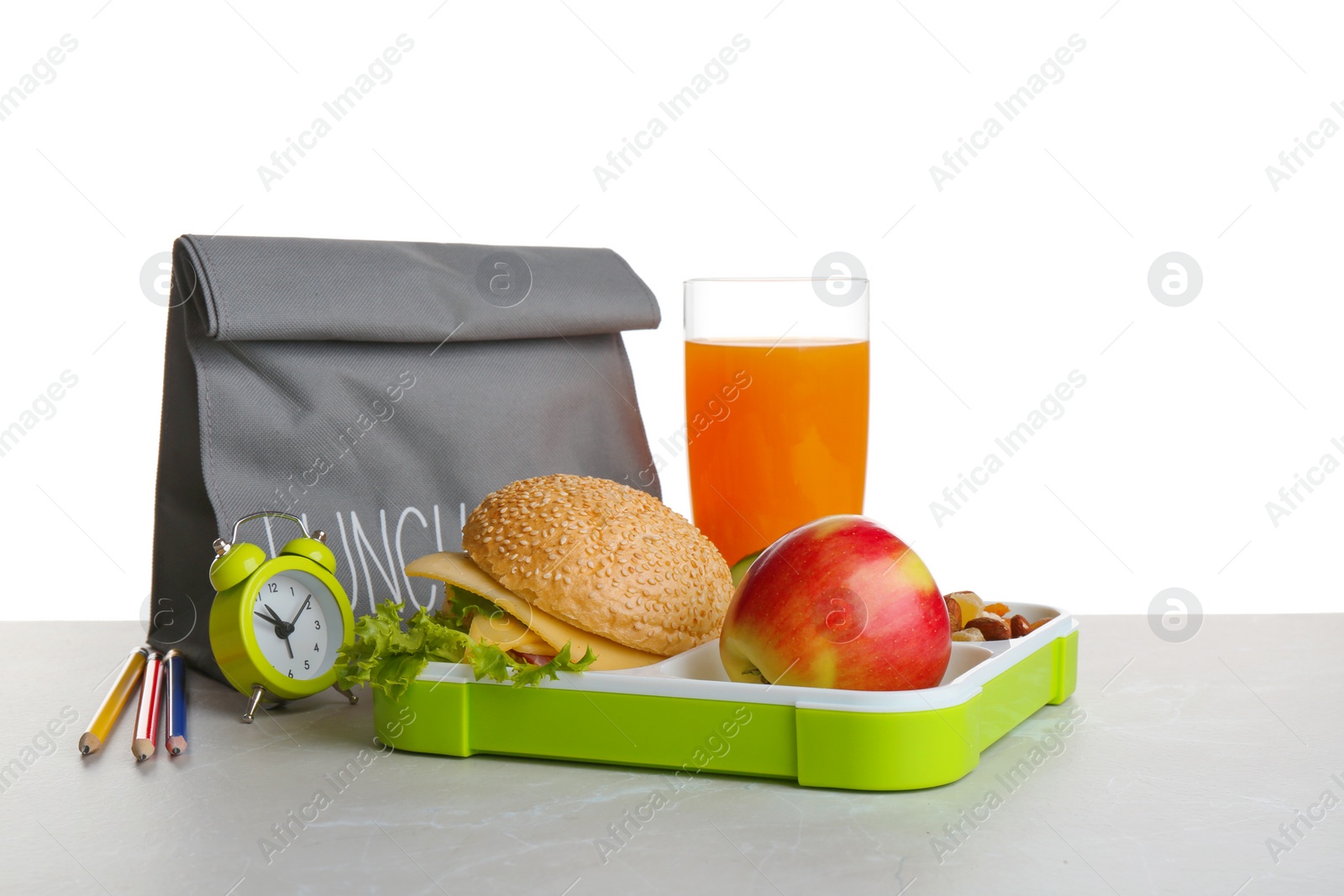 Photo of Lunch box with tasty sandwich, glass of drink and bag on table against white background