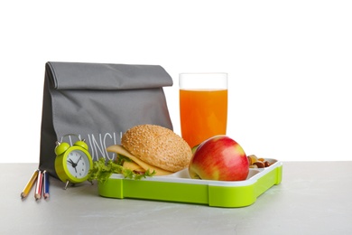 Photo of Lunch box with tasty sandwich, glass of drink and bag on table against white background