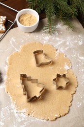 Photo of Making Christmas cookies. Raw dough and cutters on table, above view