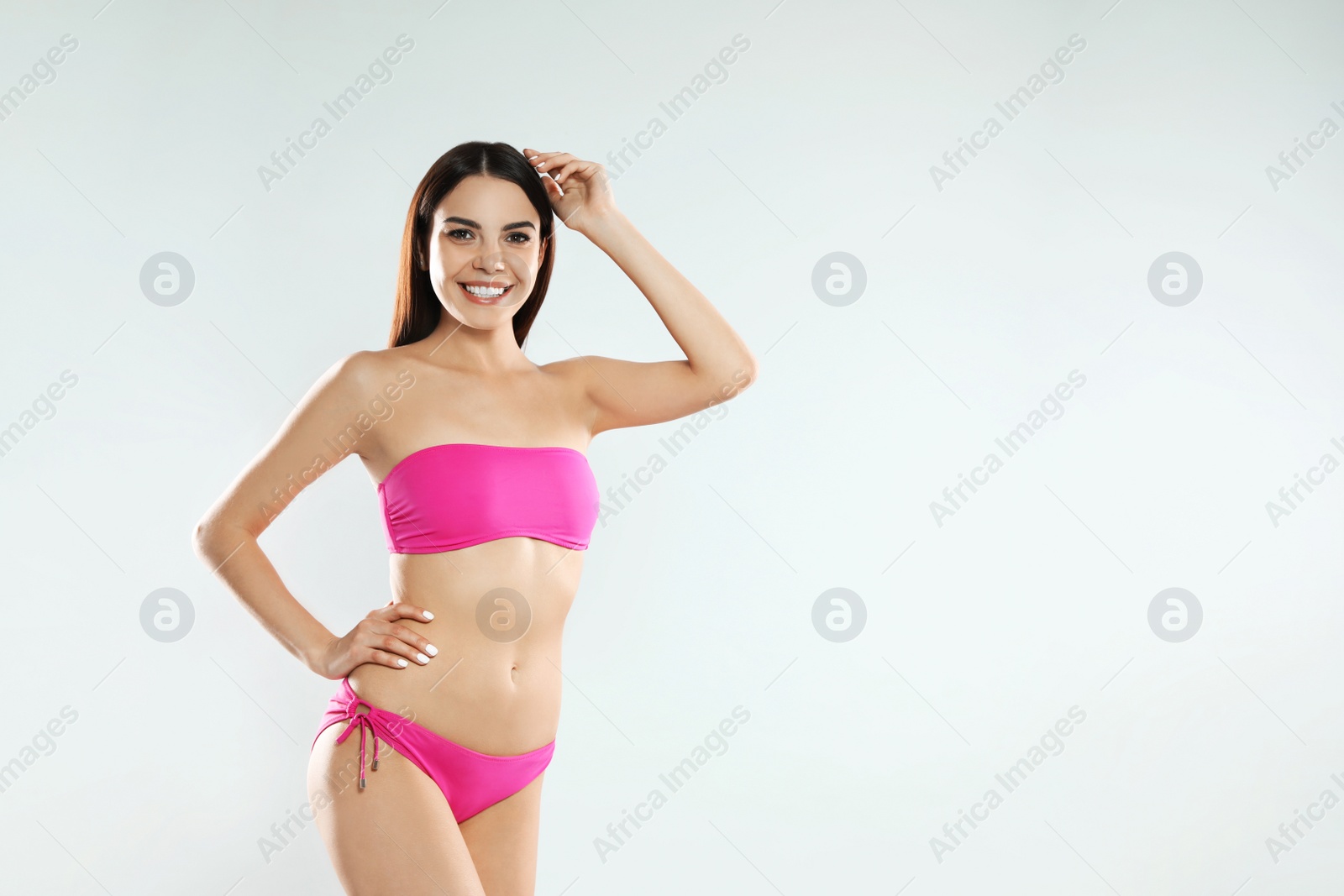 Photo of Portrait of attractive young woman with slim body in swimwear on white background. Space for text