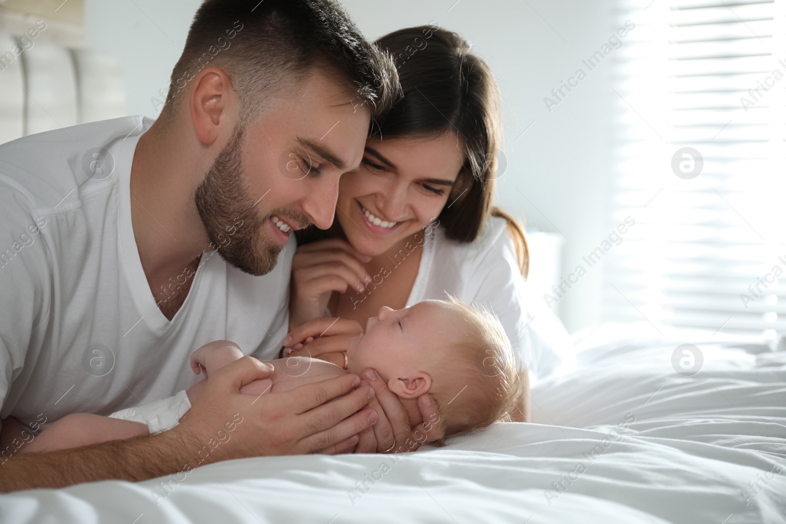 Photo of Happy couple with their newborn baby at home