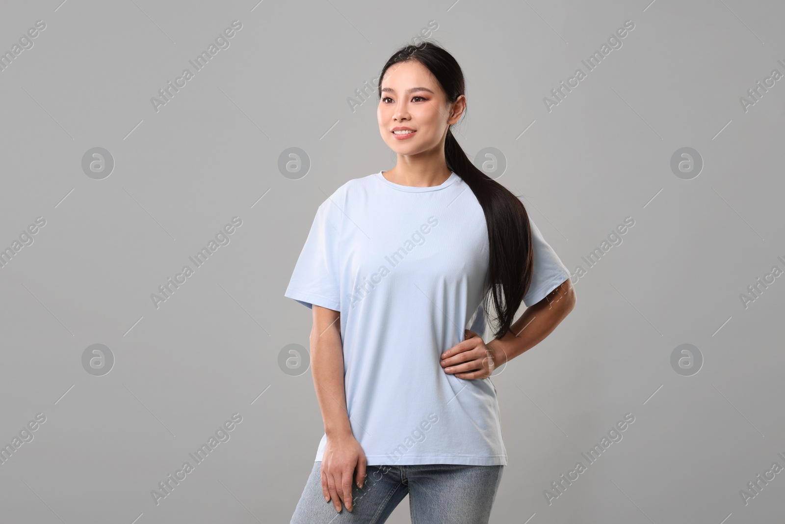 Photo of Woman wearing light blue t-shirt on grey background