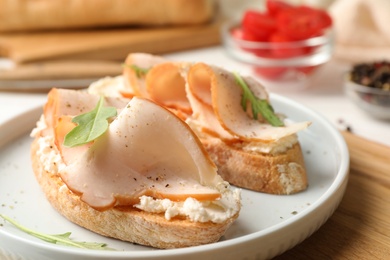 Plate of delicious chicken bruschettas on table, closeup