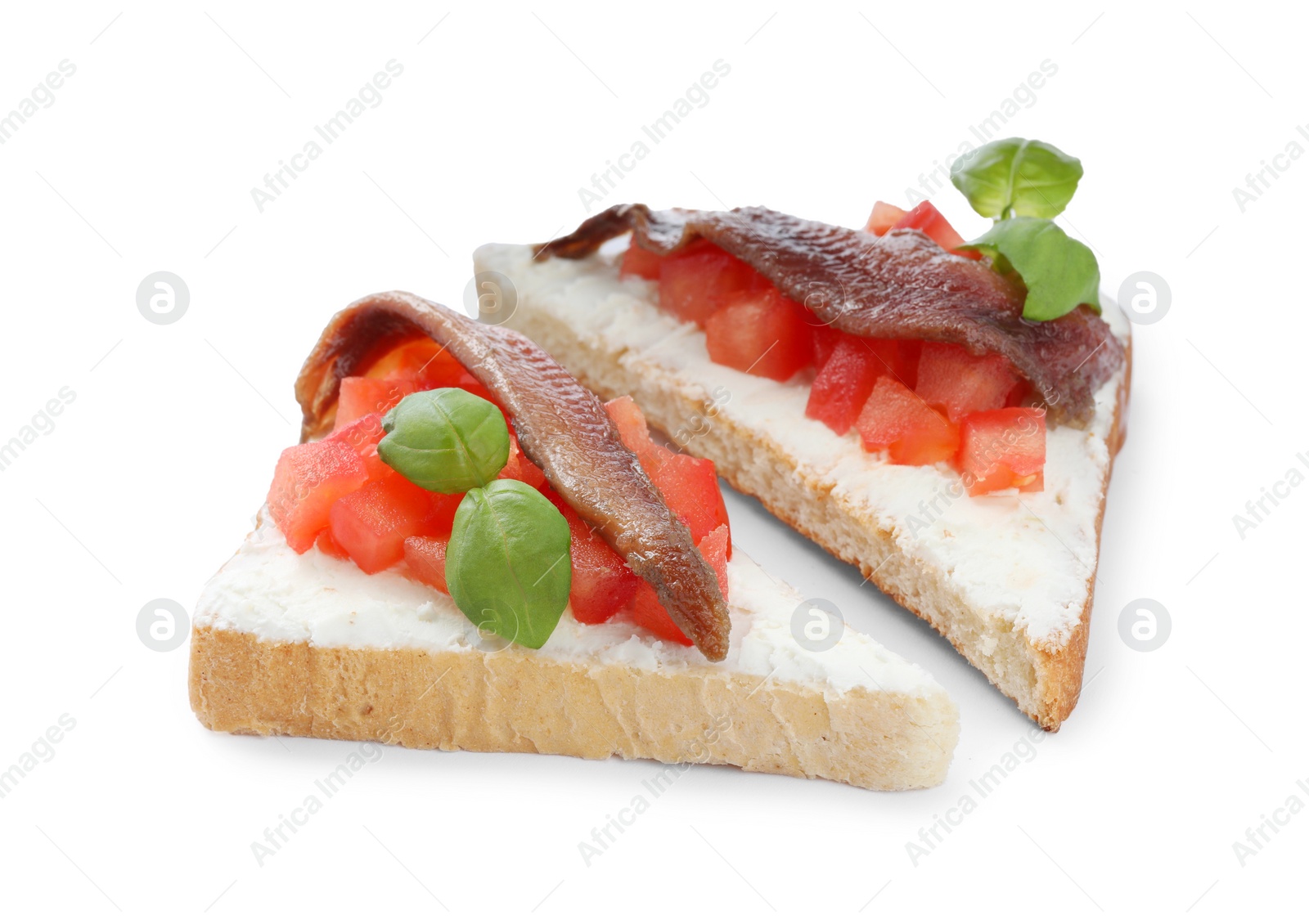 Photo of Delicious sandwiches with cream cheese, anchovies, tomatoes and basil on white background