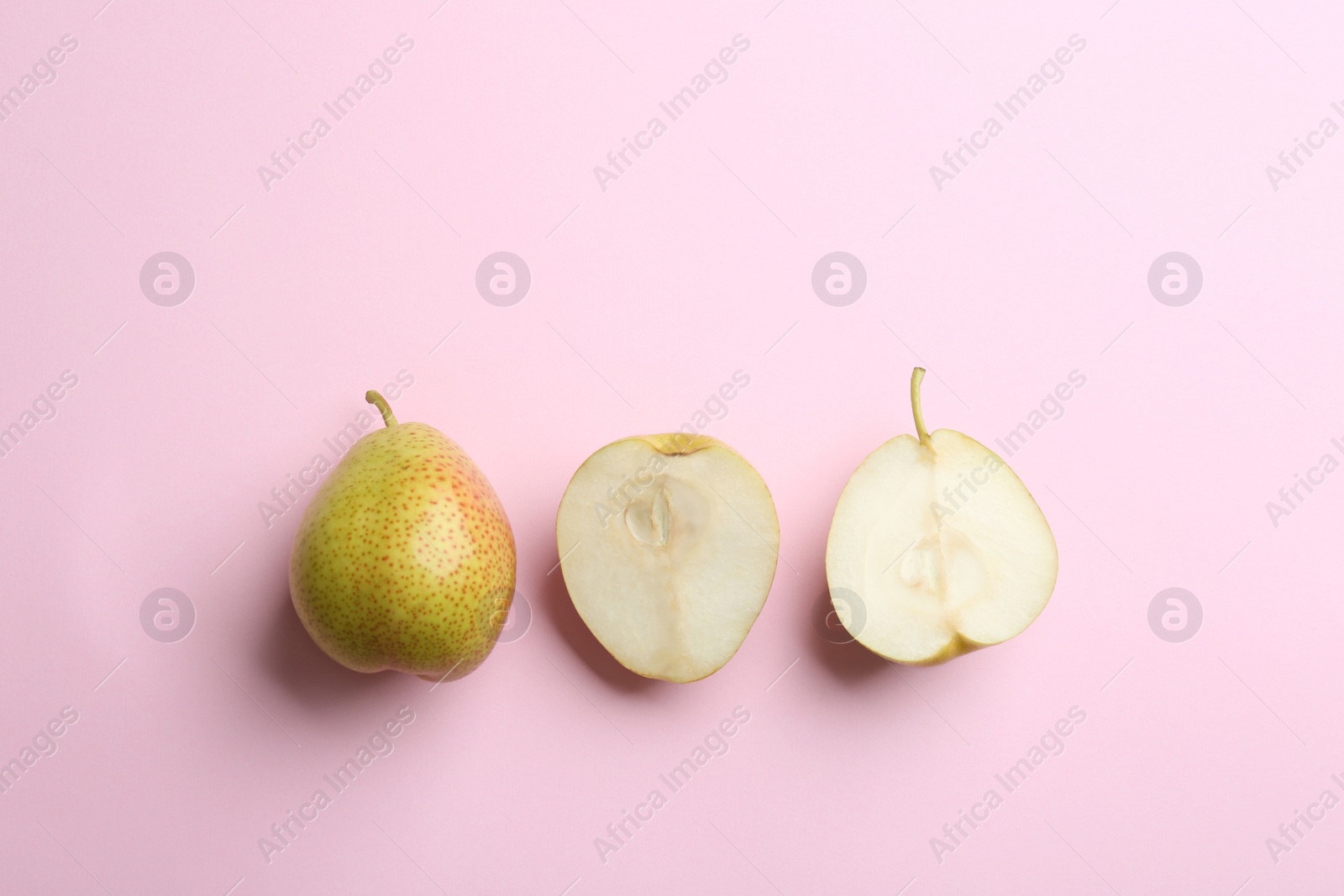 Photo of Ripe juicy pears on pink background, flat lay. Space for text