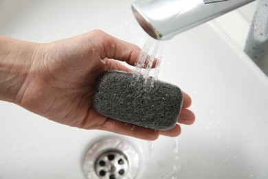 Woman pouring water onto pumice stone in bathroom, above view