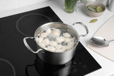Photo of Cooking delicious dumplings in pot on cooktop