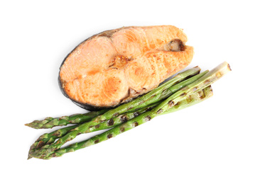 Tasty salmon steak with asparagus isolated on white, top view