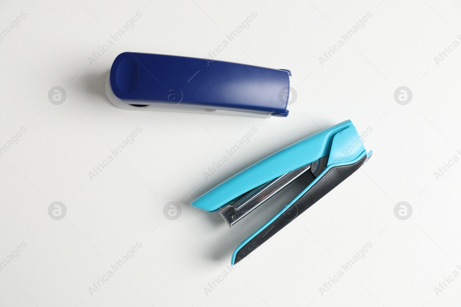 Photo of Color stapler on white table, flat lay