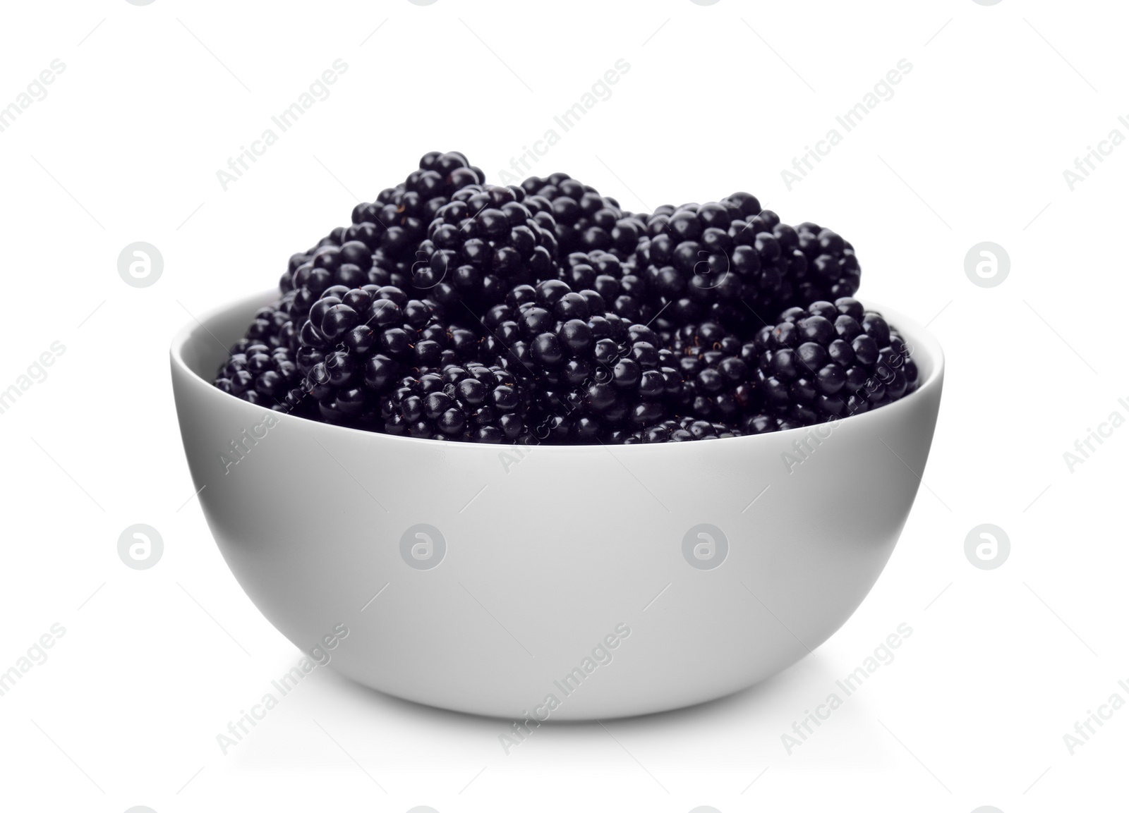 Photo of Ceramic bowl of tasty ripe blackberries on white background