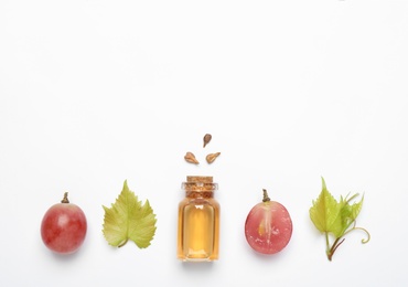 Photo of Composition with bottle of natural grape seed oil on white background, top view. Organic cosmetic