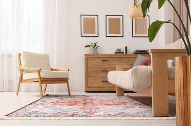 Photo of Beautiful rug, sofa, armchair and chest of drawers indoors