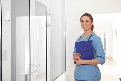 Portrait of nurse with clipboard in hospital hallway. Medical assisting