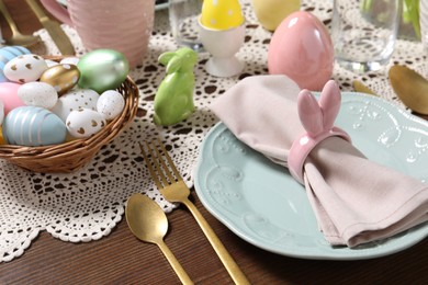 Festive table setting with napkin ring in shape of bunny ears, closeup. Easter celebration