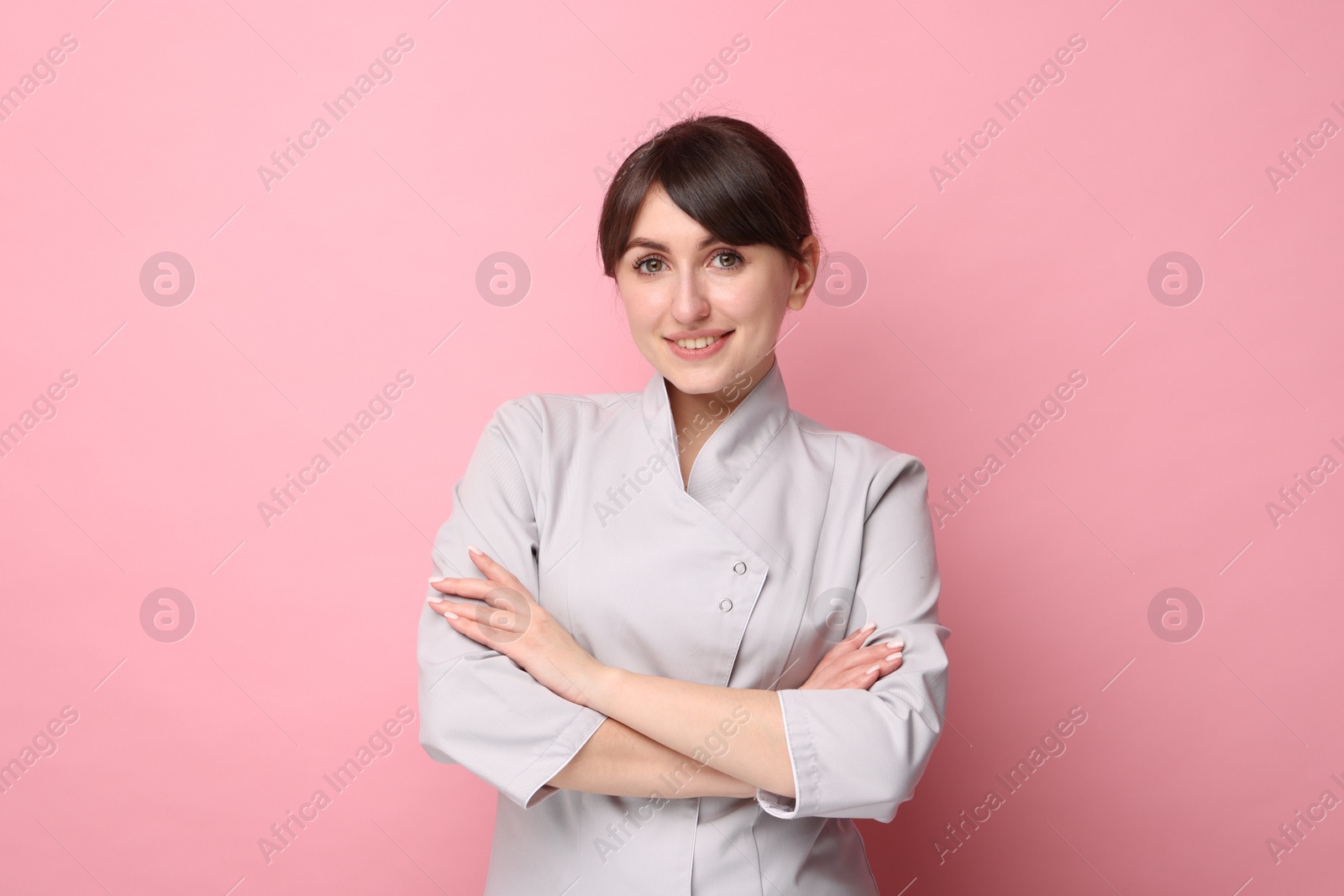 Photo of Cosmetologist in medical uniform on pink background