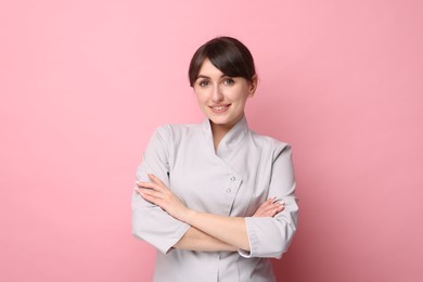 Photo of Cosmetologist in medical uniform on pink background