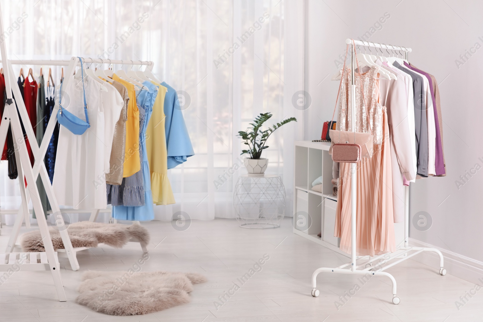 Photo of Racks with stylish clothes in light room