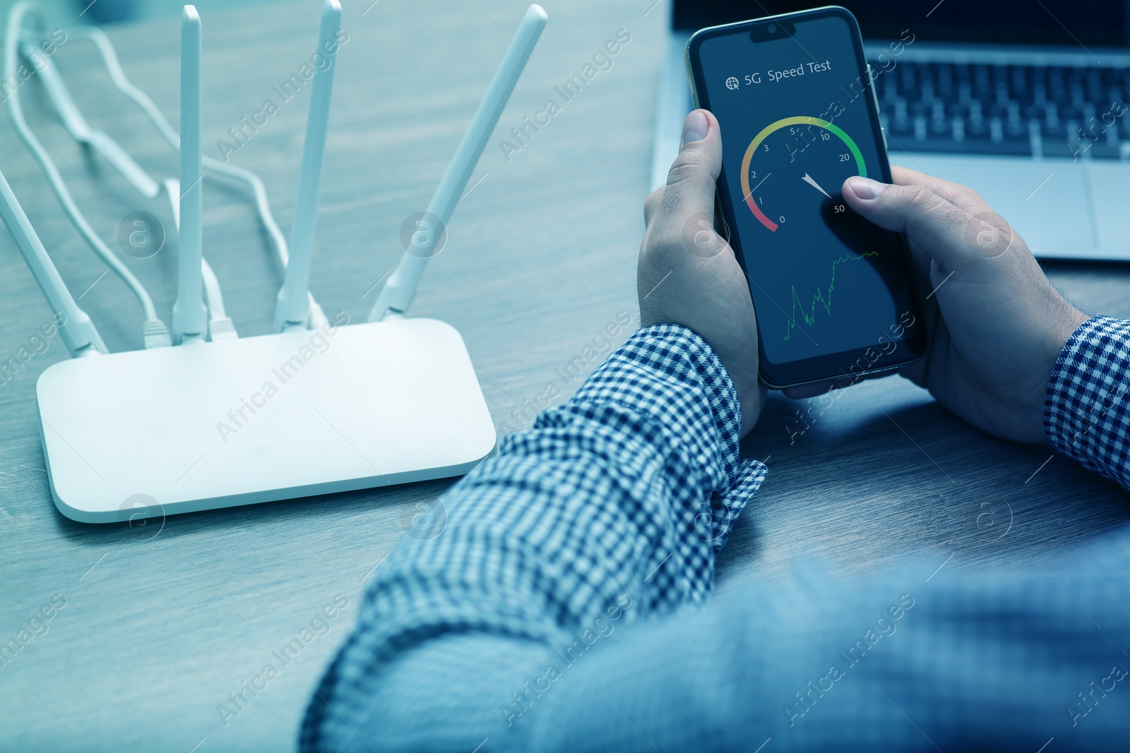 Image of 5G speed test. Man using mobile phone at table, closeup