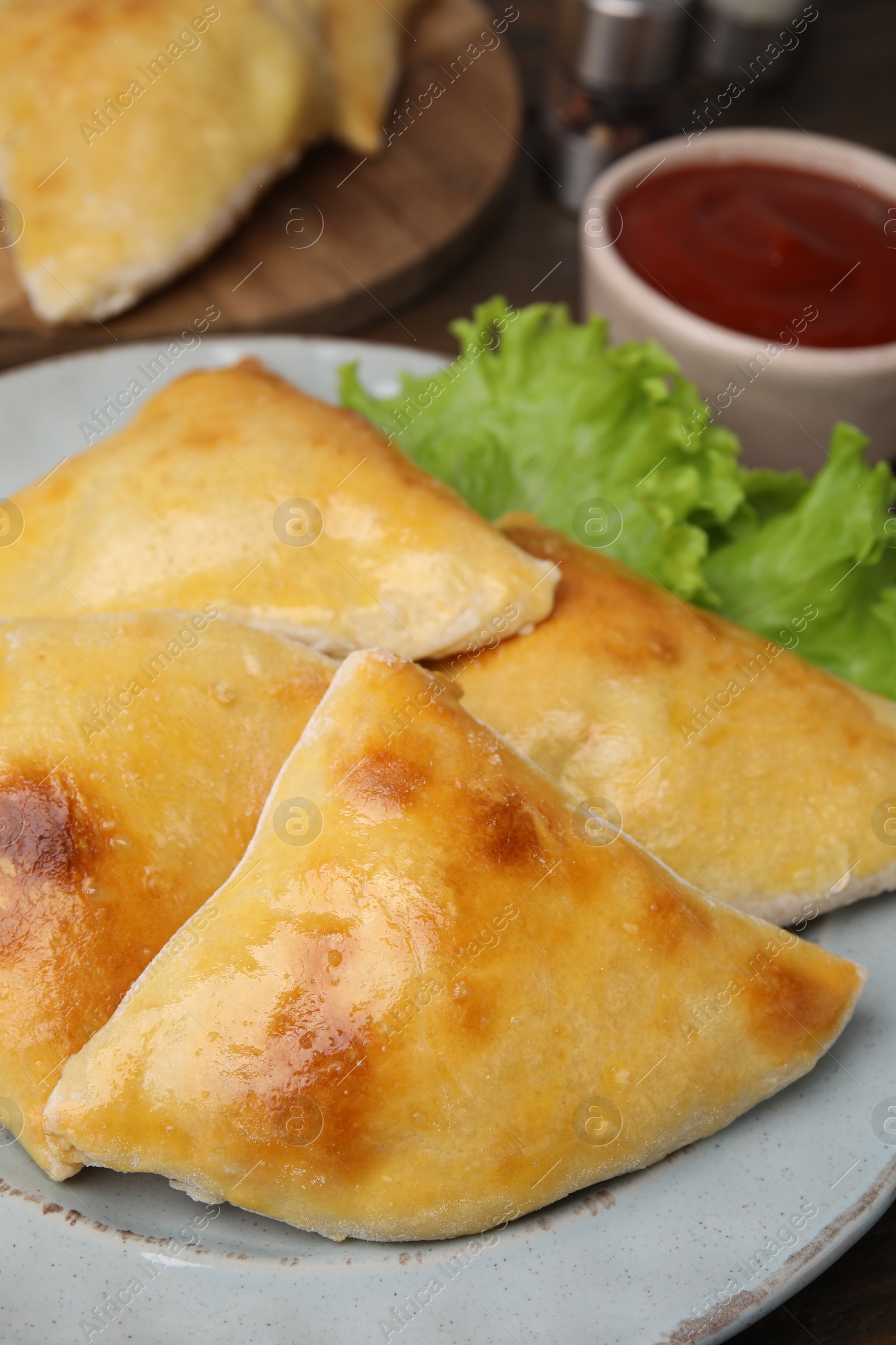 Photo of Delicious samosas and lettuce on table, closeup