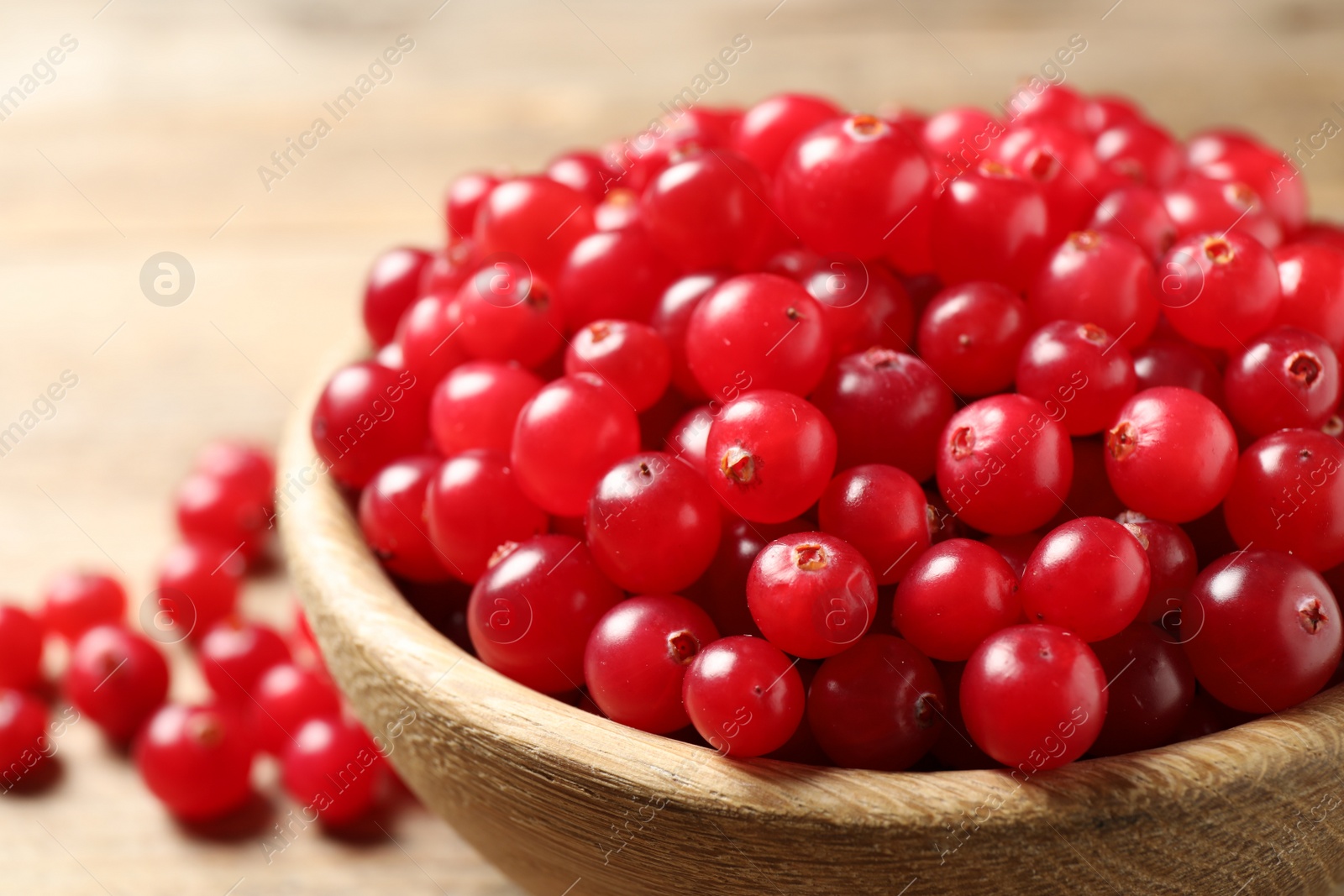 Photo of Ripe fresh cranberry in wooden bowl, closeup