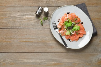 Delicious salmon carpaccio served on wooden table, flat lay. Space for text