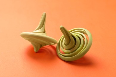 Yellow and green spinning tops on orange background